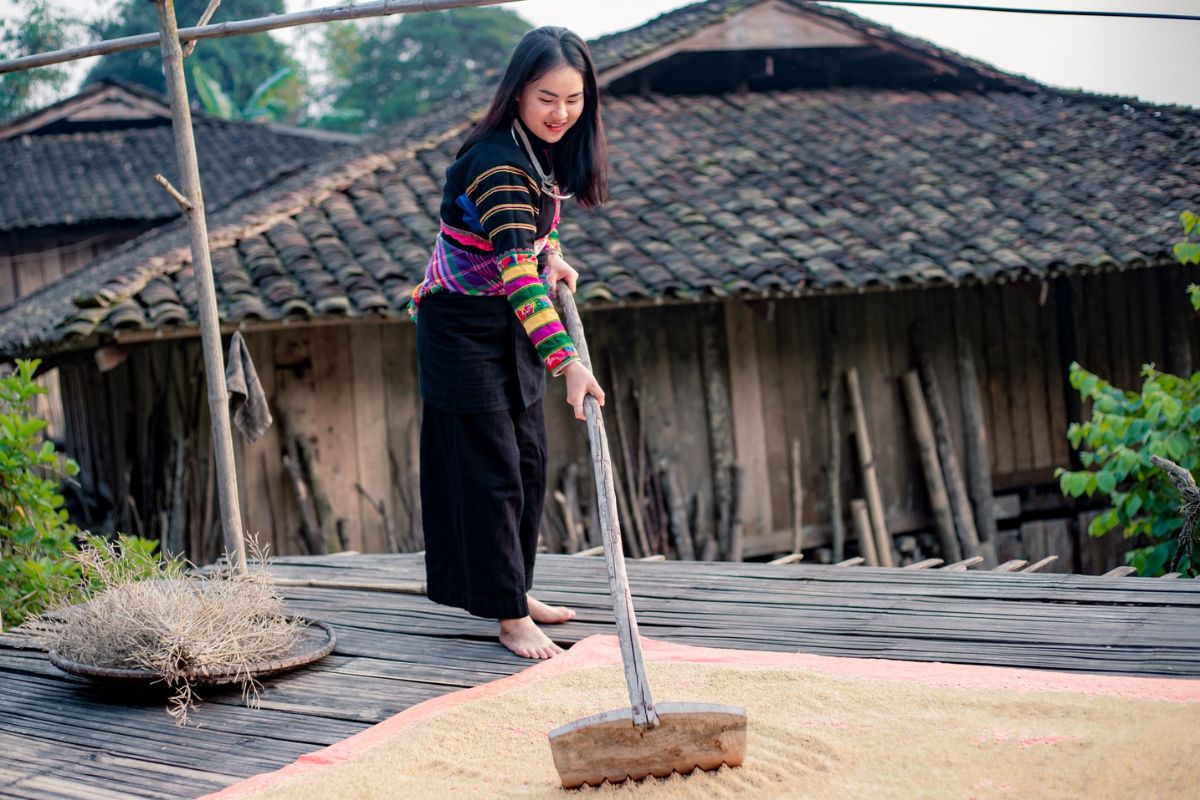 Black Lo Lo women in traditional attire walking near the village